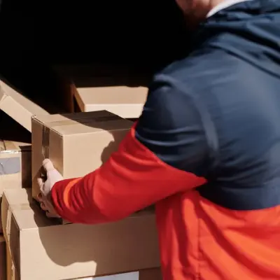 Courier carefully packing belongings into moving boxes